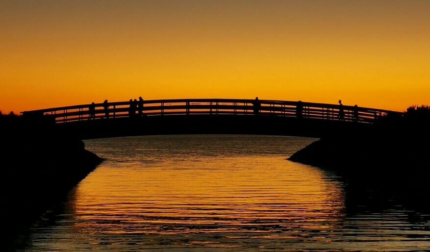 a bridge over a body of water at sunset